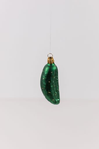 A vertical shot of a hanging bauble in the shape of a cucumber on a white background