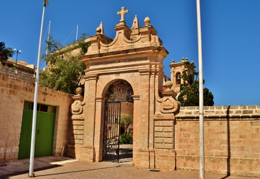 An arched doorway and metal gate leading to the Christian Sanctuary of Our Lady of Mellieha Malta