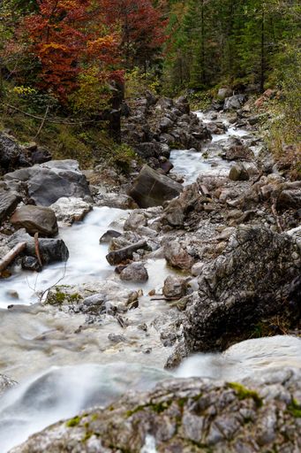 A beautiful view of waterfall water flowing through the rocks covered with moss in the Allgaeu Alps