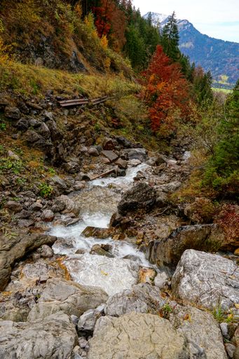 A beautiful view of waterfall water flowing through the rocks covered with moss in the Allgaeu Alps