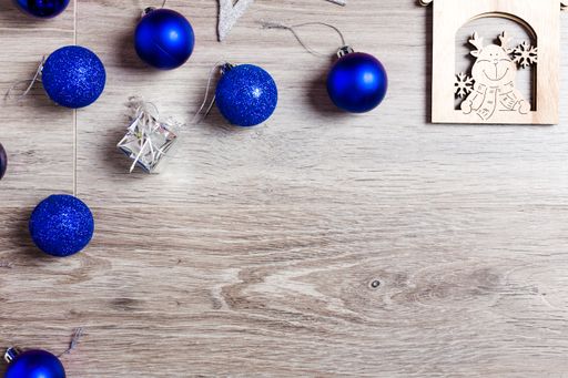 The Christmas decoration with blue ornaments with space for text on a white wooden background