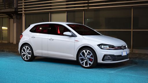 A white Volkswagen Polo GTI automobile parked alongside a building, situated on a paved road