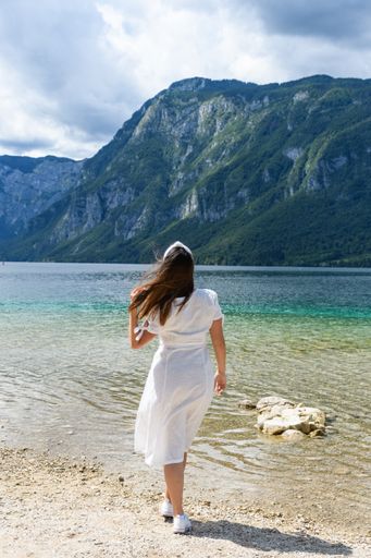 A back view of a young female enjoying view to Bohinj lake in Slovenia
