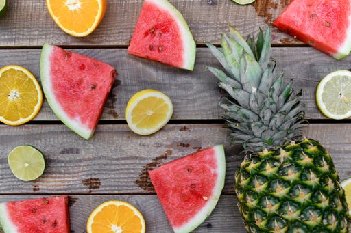 A top view of sliced fresh tropical fruits on a wooden surface