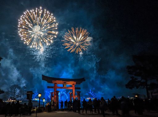 A low-angle of colorful fireworks on the night sky people near the entrance