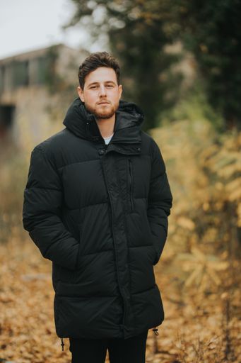 A shallow focus shot of a young and attractive male posing at camera