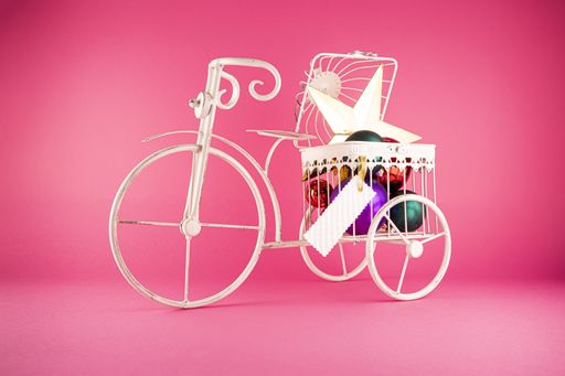 A closeup shot of a metal bicycle with Christmas toys in it