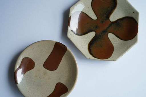 A high angle shot of two beige ceramic plates with brown patterns