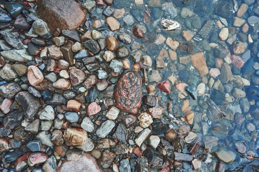 A high angle shot of wet pebbles near Lake Mjosa in Toten, Norway
