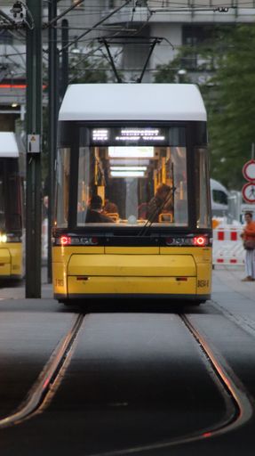 A vertical shot of a yellow tram on the rails in Berlin at Alexanderplatz