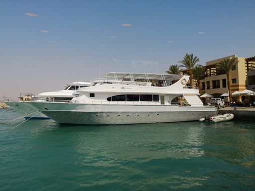 A large yacht anchored at the dock in a tranquil body of water