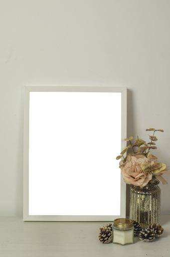 A vertical shot of an interior design of a living room with a white-framed poster with decorative elements