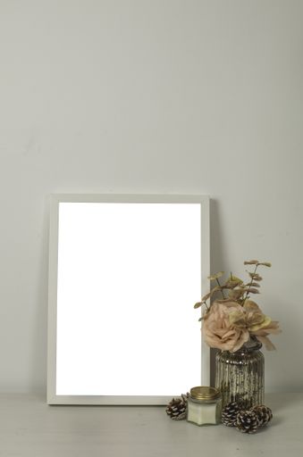 A vertical shot of an interior design of a living room with a white-framed poster with decorative elements