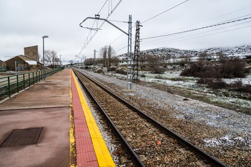 A selective focus shot of an empty train track in a railway station in the winter