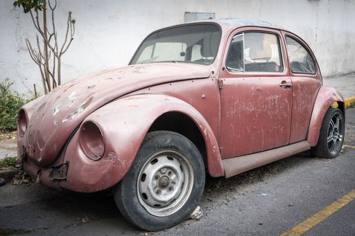A closeup of a rusty abandoned old car on a street