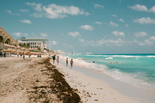 A diverse group of people enjoying a sunny day at the beach in Cancun