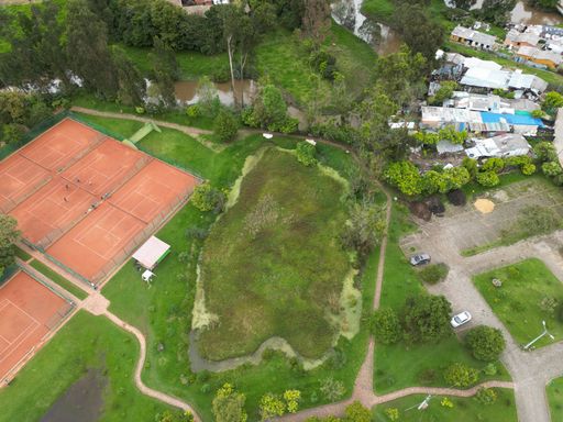 An aerial view of tennis courts surrounded by lush greenery. Chia, Cundinamarca, Colombia.