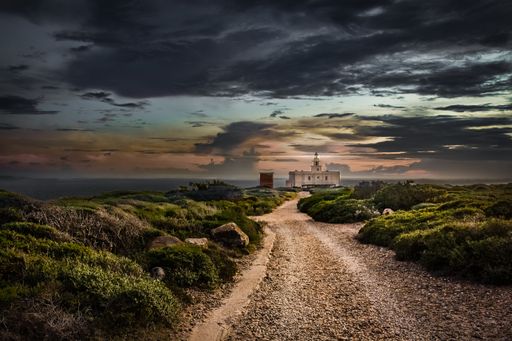 A beautiful view of a pathway near the sea in Sardegna, Italy during sunset