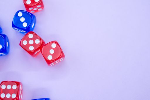A top view of red and blue dice isolated on light violet background
