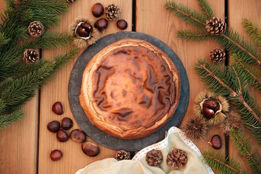 A top view of delicious chestnut cheesecake over a wooden table with autumnal decorations