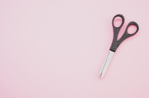 A top view of black scissors isolated on pink background