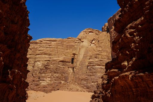 A scenic view of the rocky caverns of the Wadi Rum desert with a bright blue sky in the background