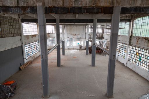 the interior of an abandoned industrial building with columns