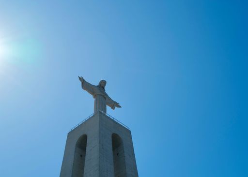 A low angle of the Cristo Rei monument with a view of blue sky in Almada, Portugal