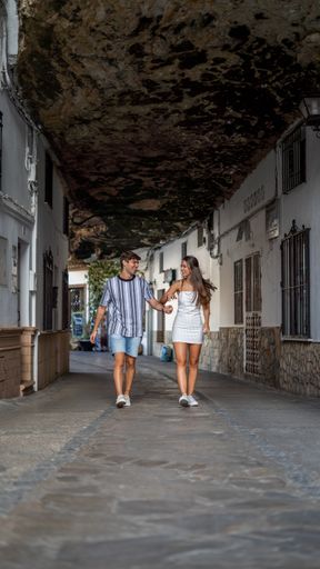 A vertical selective focus shot of a happy young couple walking