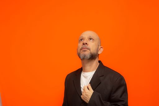 Portrait of an elegant business man looking up. Isolated on orange background.
