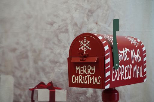 A Santa Mailbox with Merry Christmas red and white with green stripe presents ribbon bow