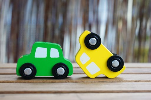A closeup shot of car toys on a wooden surface - car crash concept