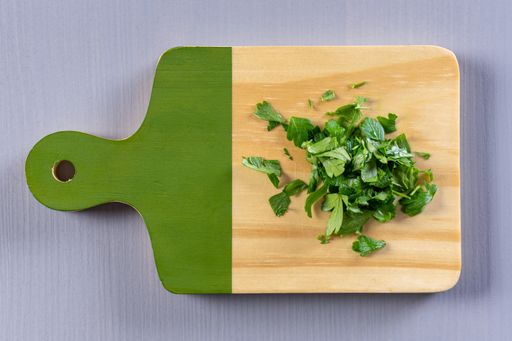 A top view of chopped fresh parsley on a wooden board