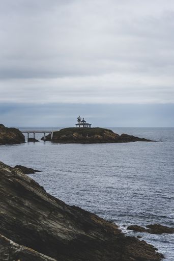 The Isla Pancha island surrounded by the sea under a cloudy sky during daytime in Spain