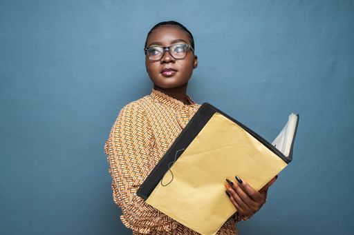 A closeup shot of a young lady holding a file of documents