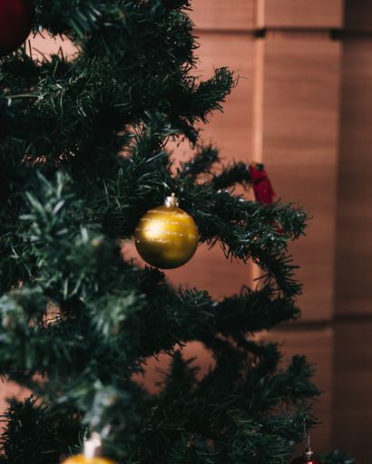 A vertical closeup shot of decorating a Christmas tree