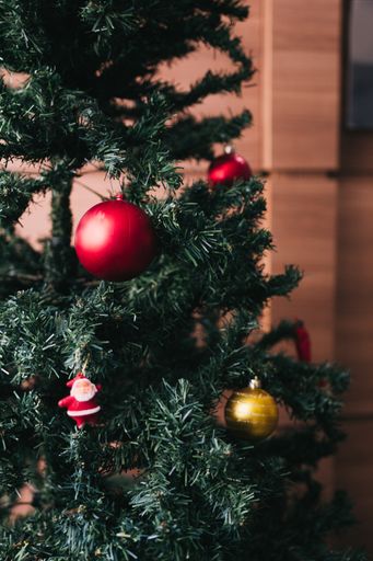A vertical closeup shot of decorating a Christmas tree