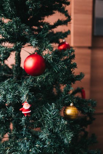 A vertical closeup shot of decorating a Christmas tree