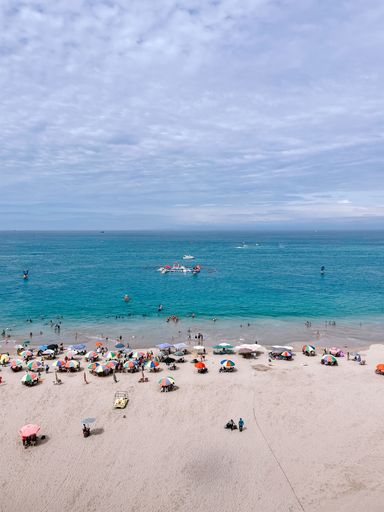 A vertical shot of the people resting at the beach on a sunny day