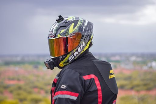 A motorcyclist wearing a riding jacket and SMK helmet