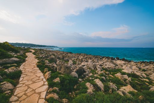 A beautiful cobblestone road at the shore of the ocean on a gloomy day