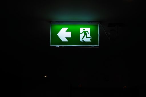 An emergency exit sign hanging on ceiling