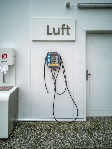 A box for one-time plastic gloves and an air pressure meter at a gas station in Germany