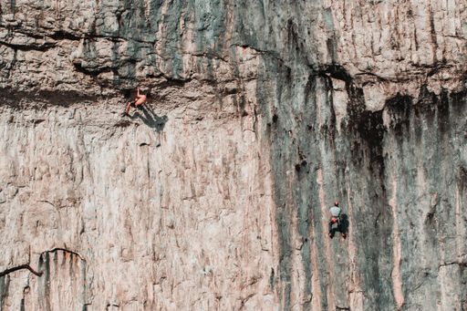 Wide shot of two men climbing the face of malham cove.