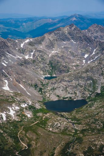 An aerial scene of Rocky mountain hiking on Colorado trails with a lake under blue sky