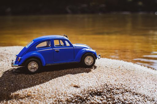A cool blue vintage car parked at the river shore