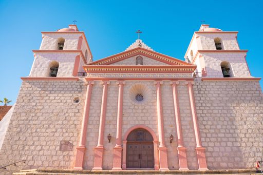 A low angle shot of the chapel at Mission Santa Barbara against the background of a blue sky