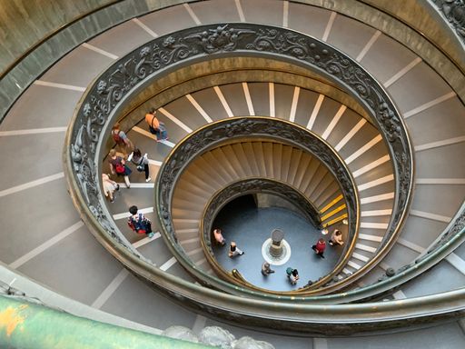 A high-angle shot of people at the spiral staircase inside a building in the Vatican, Rome, Italy