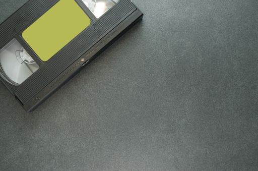 A high angle shot of a videotape on a black surface