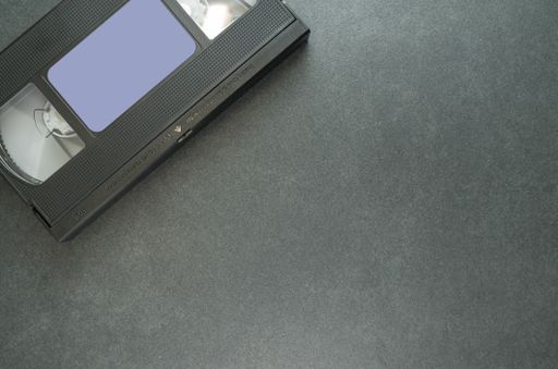 A high angle shot of a videotape on a black surface